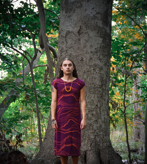 bobby is wearing the zero waste anja dress standing in a forest